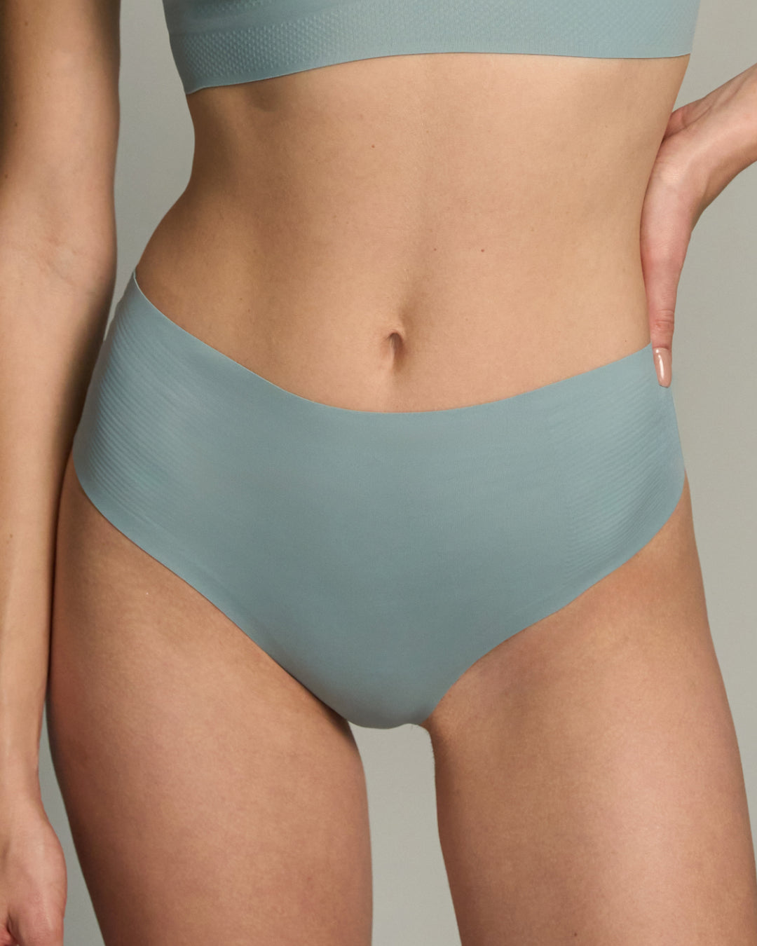Person wearing a Arona Blue wireless bra and panty set against a neutral background